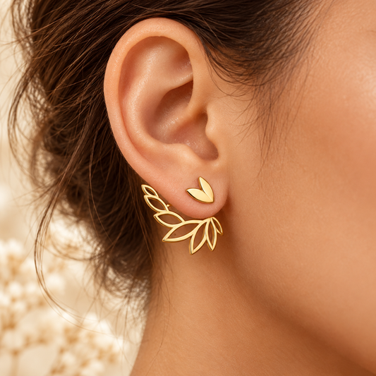 Boucles Élyna dorées portées, petit cœur devant l’oreille et feuillage derrière le lobe