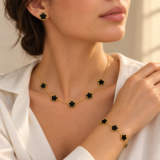 Parure Florélia noire et dorée portée par une femme : collier, bracelet et puce d’oreille