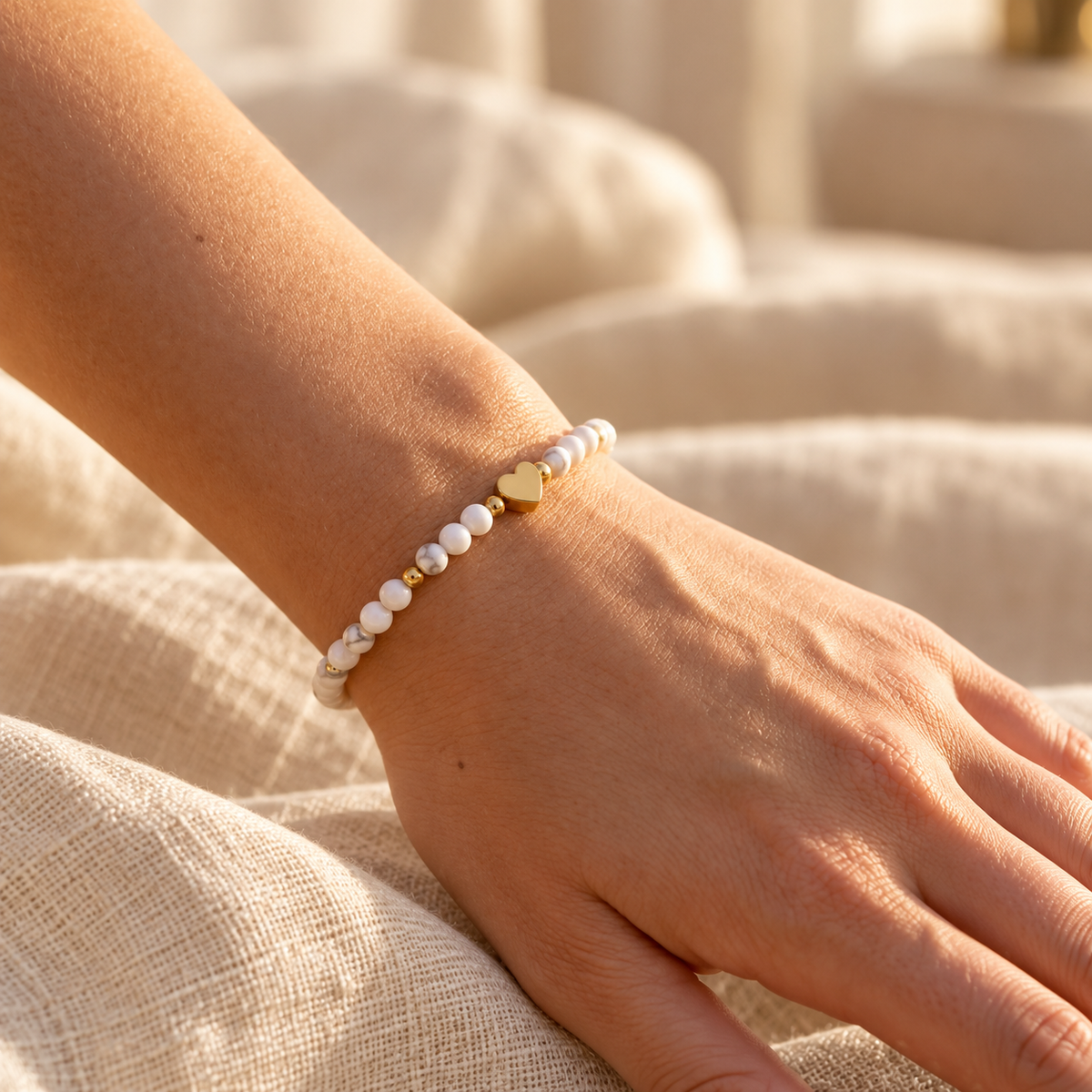Bracelet Amélia Cœur à perles blanches et cœur doré porté par une femme