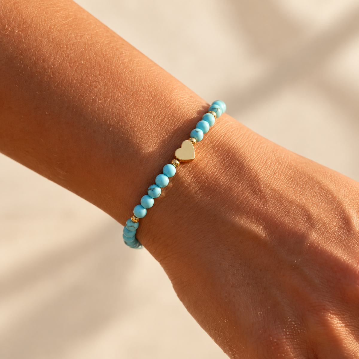 Détail des perles bleues, des séparateurs dorés et du cœur du bracelet Amélia