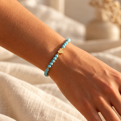 Bracelet Amélia Cœur à perles bleues et cœur doré porté au poignet