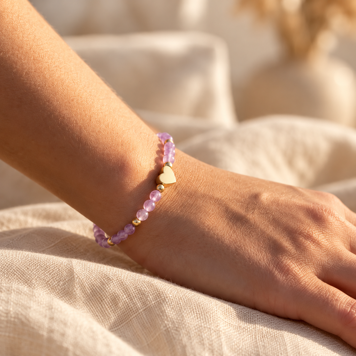 Bracelet Amélia Cœur à perles violettes et détails dorés porté au poignet