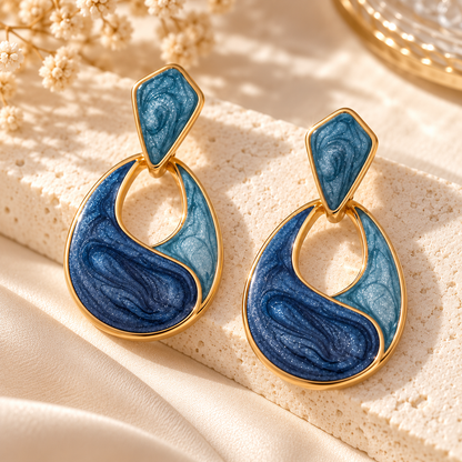 Gros plan de la résine marbrée bleu nuit et bleu clair et des contours dorés des boucles Maélys