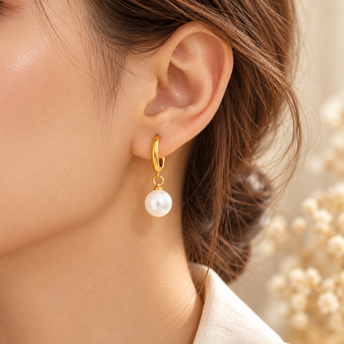 Créole Perla portée à l'oreille, anneau doré et perle blanche suspendue