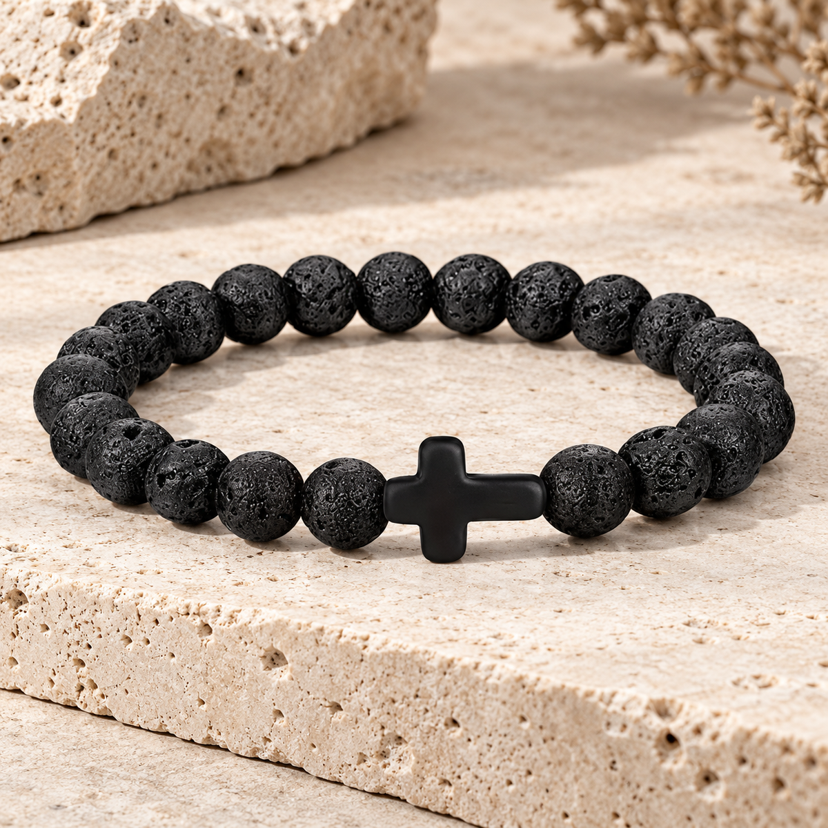 Bracelet élastique homme à perles noires texturées avec croix noire sur pierre beige