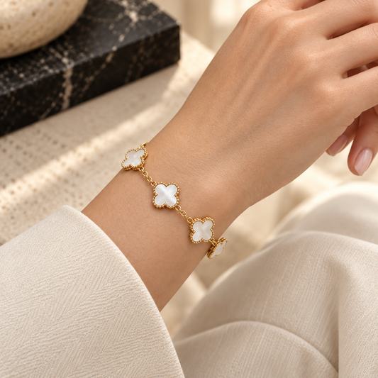 Bracelet doré à trèfles blancs porté au poignet