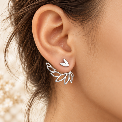 Boucles Élyna argentées portées, cœur visible devant et feuillage ajouré derrière le lobe