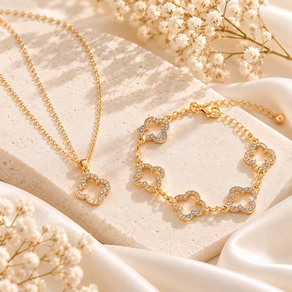 Parure Lyséa collier et bracelet trèfles dorés scintillants sur pierre ivoire, photographie claire